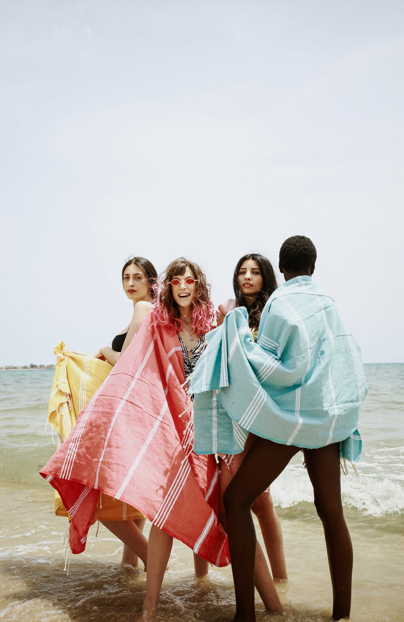 Eine Gruppe von Mädchen am Strand die ein anderes Strandtuch hamamtuch tragen