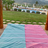 ein aquablaues Strandtuch und eine rosa Fouta für den Pool