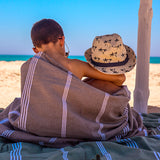 zwei Kinder am Strand bedeckt mit einem khakifarbenen XXL Strandtuch Fouta