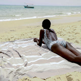 ein Mädchen am Strand auf einem taupefarbenen XXl Strandtuch liegend