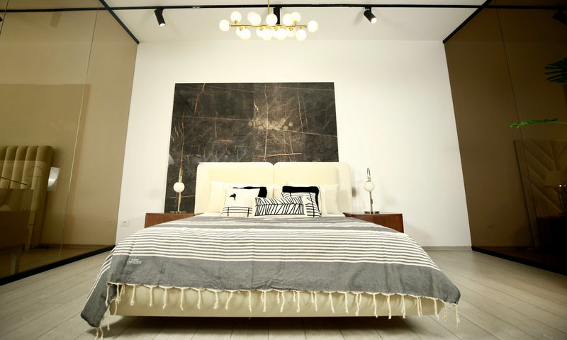 ein großes Bett mit einer grauen Bettüberwurf Decke