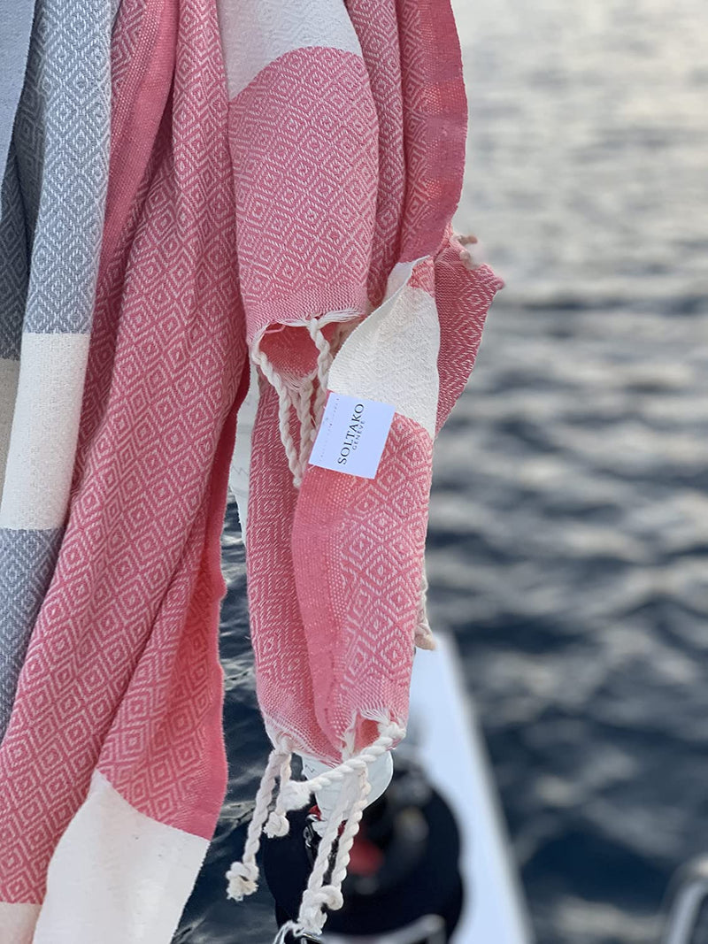 khakifarbenes Hamamtuch und rosa Strandtuch auf einem Boot