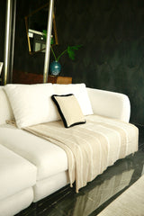 eine cremefarbene Sofaüberwurf auf einem weißen Sofa
